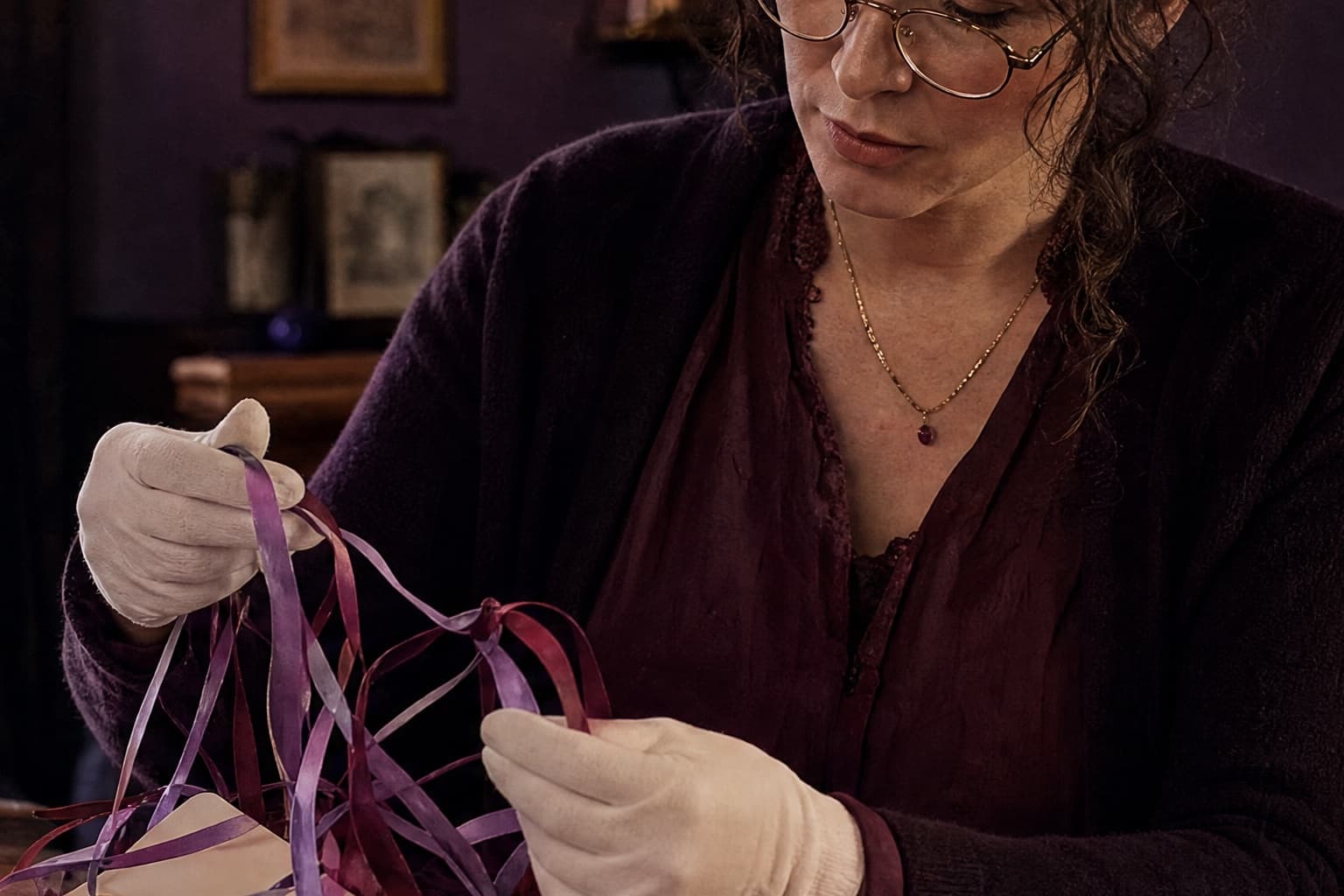 Adult archivist untangling colored ribbons from blank story cards